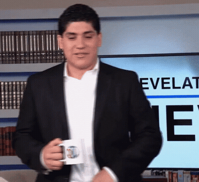 Man In Suit Holding Coffee Mug In Front Of Screen Saying Revelati GIF