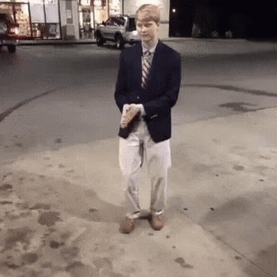 Man In Suit Holding Coffee On Sidewalk GIF