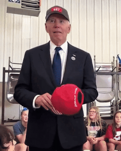 Man In Suit Holding Donald Trump Hat GIF