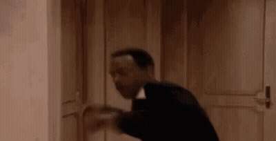Man In Suit Holding Door Open In Hallway GIF