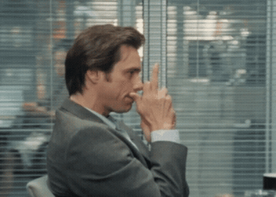 Man In Suit Holding Finger To Nose GIF