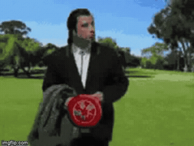 Man In Suit Holding Frisbee In Park GIF