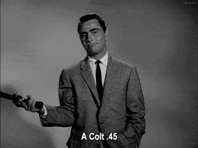 Man In Suit Holding Gun And Saying Colt 45 GIF