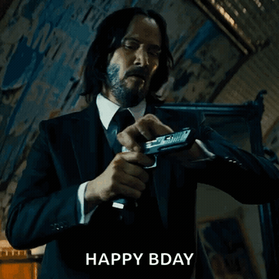 Man In Suit Holding Gun Saying Happy Bday GIF