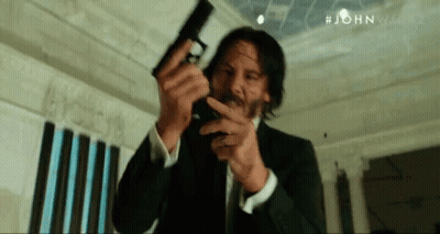 Man In Suit Holding Gun GIF