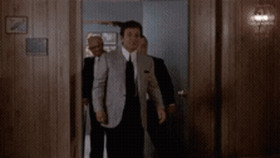 Man In Suit Holding Gun To Ear GIF