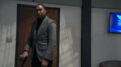 Man In Suit Holding Gun Walking Through Doorway GIF