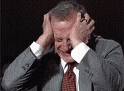 Man In Suit Holding Head In Pain GIF