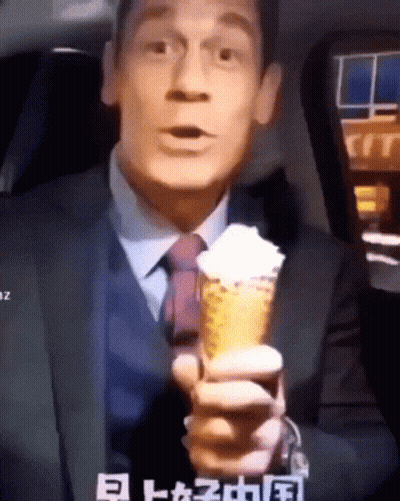 Man In Suit Holding Ice Cream Cone With Whipped Cream GIF