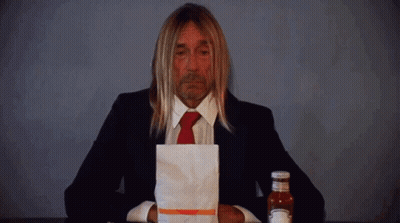 Man In Suit Holding Ketchup Bag Next To Bottle GIF