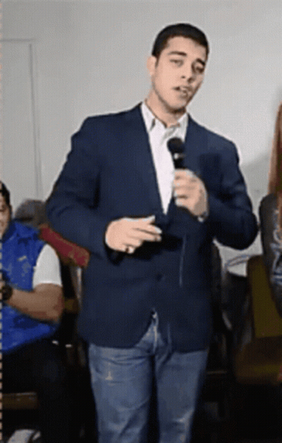 Man In Suit Holding Microphone GIF