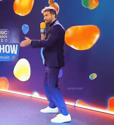 Man In Suit Holding Microphone Saying How Music GIF