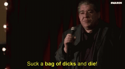 Man In Suit Holding Microphone Saying Suck A Bag Of Dicks And Die GIF
