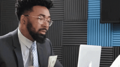 Man In Suit Holding Money In Front Of Laptop GIF
