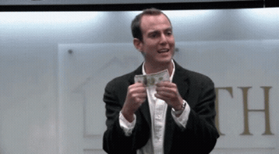 Man In Suit Holding Money In Front Of Sign Saying Th GIF
