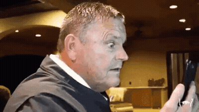 Man In Suit Holding Phone Making Funny Face GIF