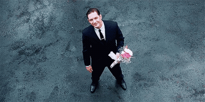 Man In Suit Holding Pink Flowers GIF