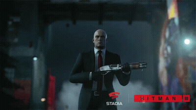 Man In Suit Holding Shotgun In Front Of Stadia Hitman III Sign GIF