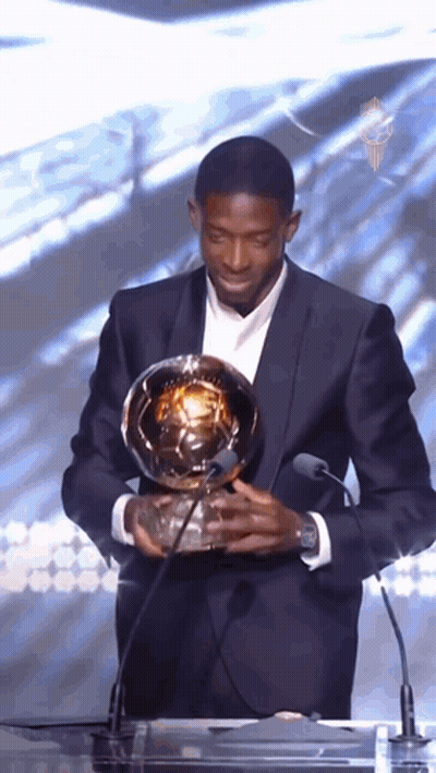 Man In Suit Holding Soccer Ball At Microphone GIF