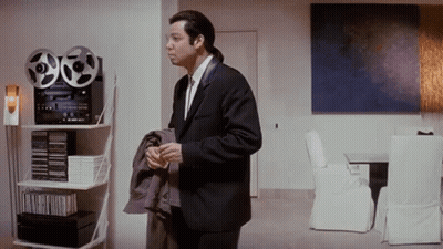 Man In Suit Holding Tape Recorder In Living Room GIF