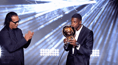 Man In Suit Holding Trophy At Microphone GIF