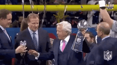 Man In Suit Holding Trophy Next To Another Man GIF