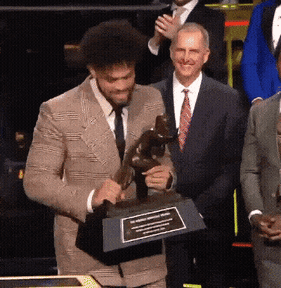 Man In Suit Holding Trophy With Plaque GIF
