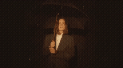 Man In Suit Holding Umbrella In Rain GIF