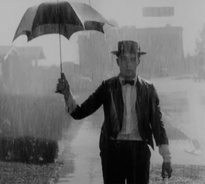 Man In Suit Holding Umbrella In Rain GIF