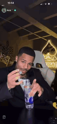 Man In Suit Holding Water And Smoking Cigarette GIF