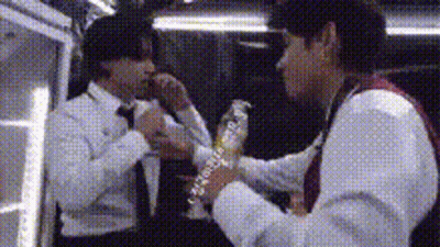 Man In Suit Holding Water Bottle Another Man Watching GIF