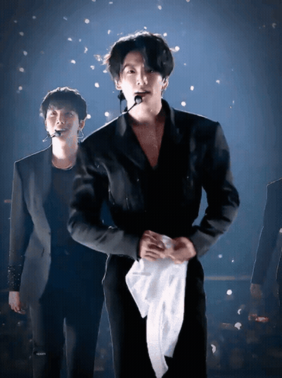Man In Suit Holding White Towel Around Waist GIF
