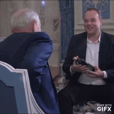 Man In Suit Holding Wine Bottle Talking To Another Man In Suit GIF