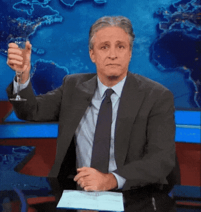 Man In Suit Holding Wine Glass In Front Of World Map GIF