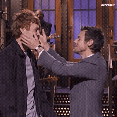 Man In Suit Hugging Another Man In Front Of Band GIF
