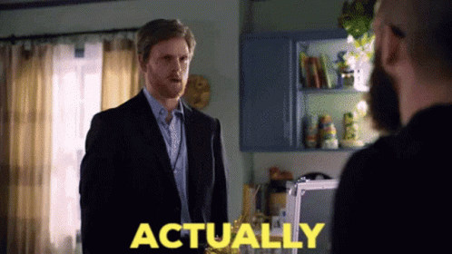 Man In Suit In Front Of Another Man With Actually In Yellow GIF