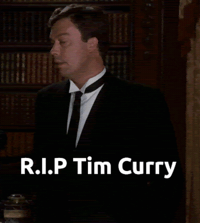 Man In Suit In Front Of Bookshelf R.I.P. Tim Curry GIF