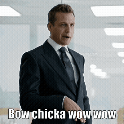 Man In Suit In Front Of Bow Chicka Wow Wow Sign GIF