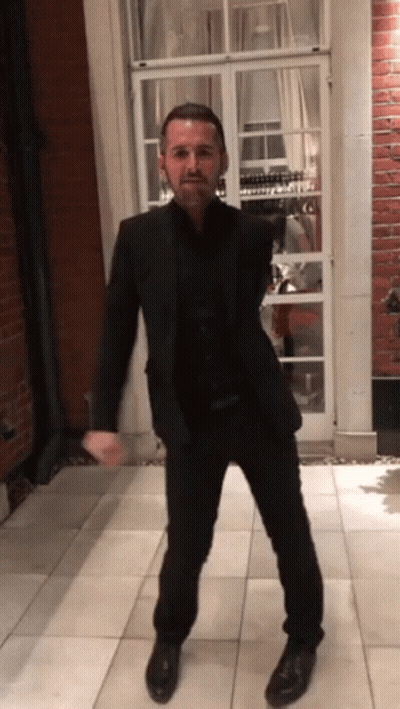 Man In Suit In Front Of Brick Building GIF