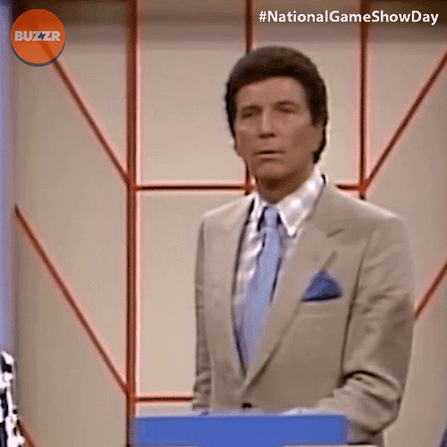 Man In Suit In Front Of Buzzr Sign GIF