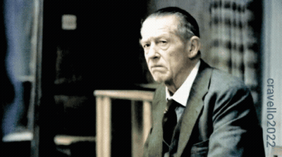 Man In Suit In Front Of Cravello 2002 Sign GIF