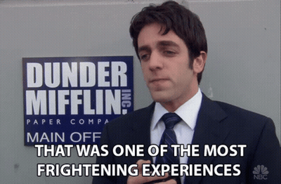 Man in Suit in Front of Dunder Mifflin Sign