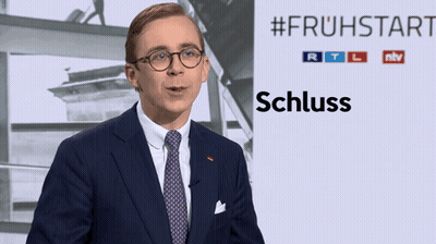 Man In Suit In Front Of #Frühstart Sign GIF