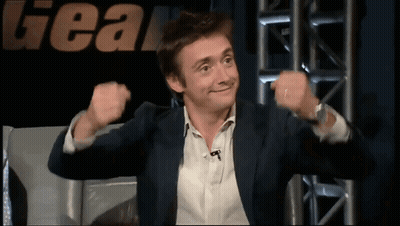 Man In Suit In Front Of Gear Sign GIF