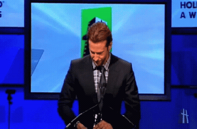 Man In Suit In Front Of Hollywood Awards Screen GIF