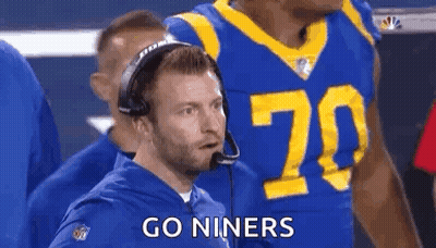 Man In Suit In Front Of Los Angeles Rams Logo GIF