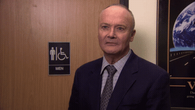 Man In Suit In Front Of Men's Restroom GIF