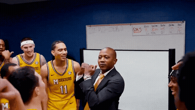 Man In Suit In Front Of Missouri Players GIF