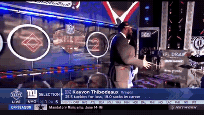 Man In Suit In Front Of NFL Draft Wall GIF