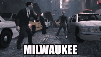 Man In Suit In Front Of Police Car With Milwaukee GIF